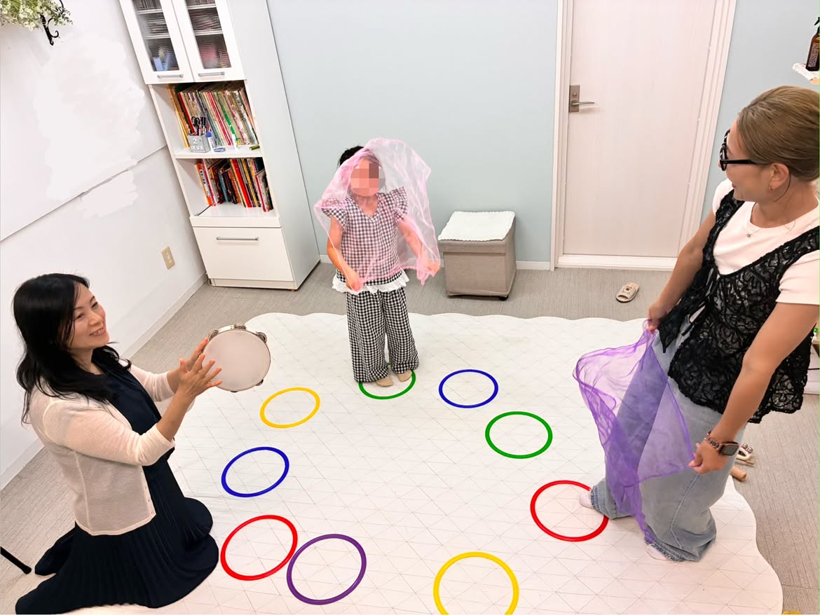 カラフルな輪とスカーフをつかったリトミックのレッスン風景